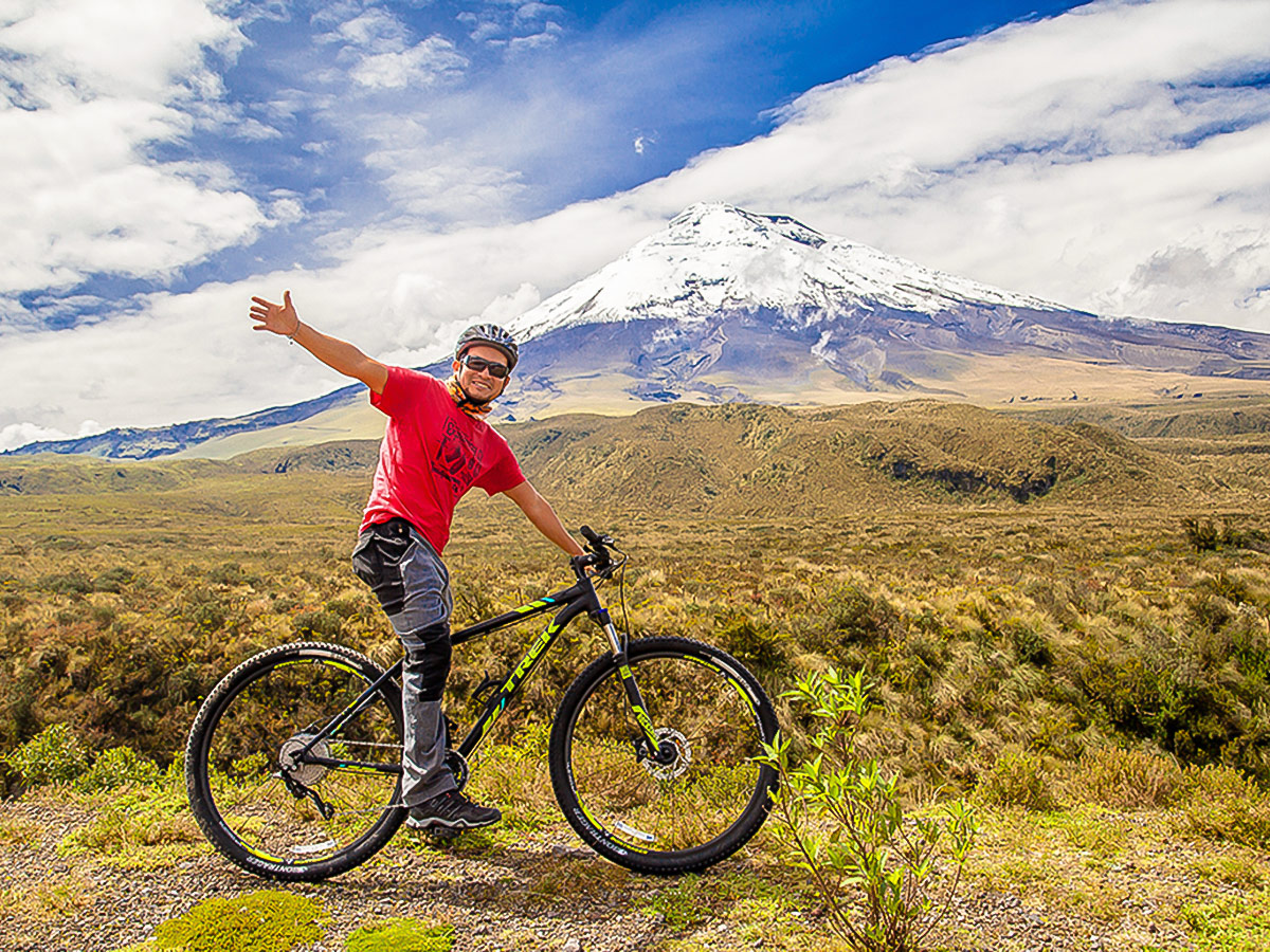 Biker in front of Cotopaxi on Cross Country Cycling in Ecuadorian Andes