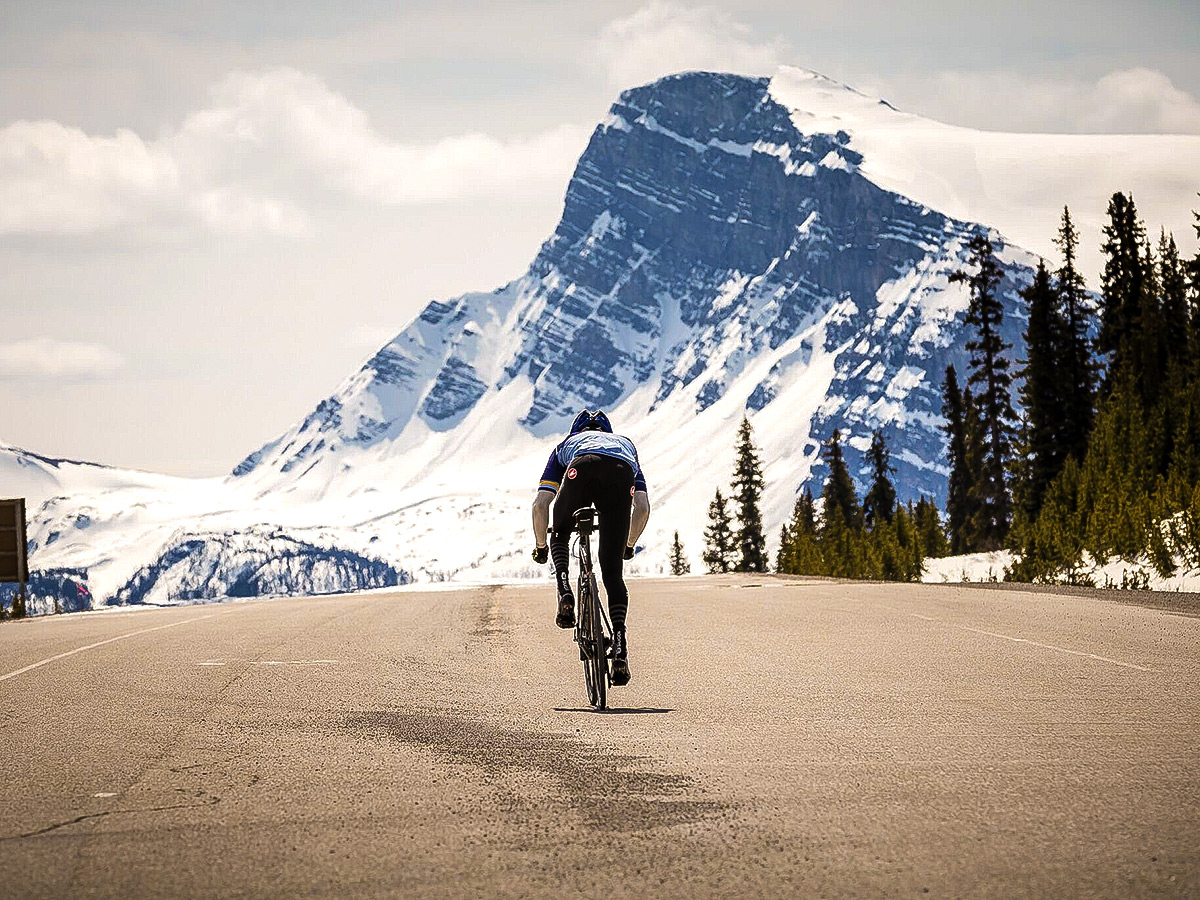 Approaching the snowy mountains on guided cycling tour from Jasper to Banff in Canada