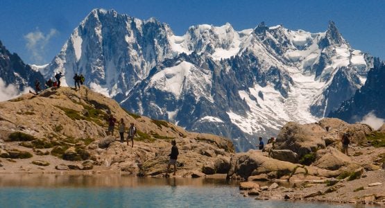 Group of hikers near the lake on Tour de Mont Blanc in French Alps