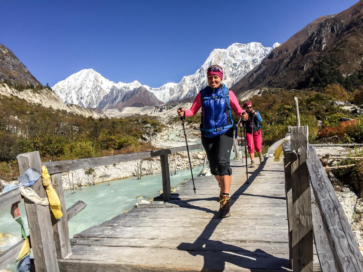 Happy hikers crossing the river on Manaslu Circuit trek in Nepal