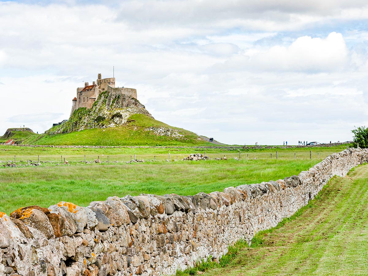 Beauitful castle on the hill seen on Northumberland and the Lake District guided walking tour in England