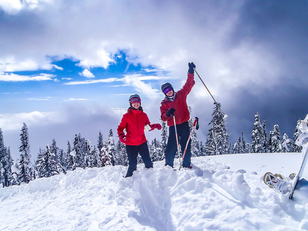 Two skiers posing on the mountain on a guided skiing trip in the Canadian Rocky Mountains