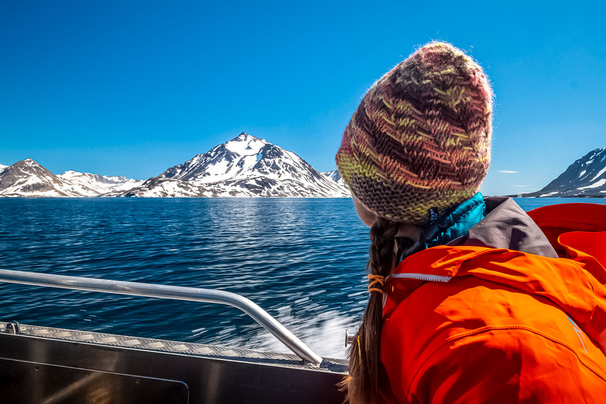 Hiker gazes at beautiful sea ocean along boat transportation along adventure tour Greenland