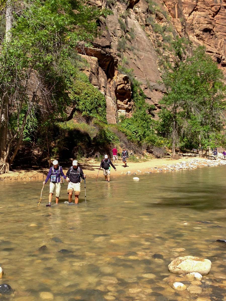 Hikers crossing river trekking hikinh Bryce Canyon Zion National Park USA