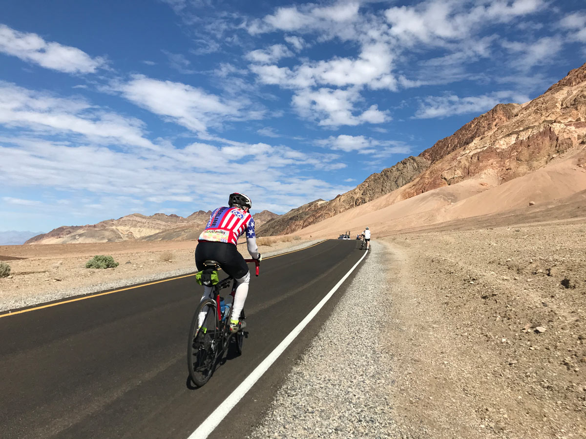 Cyclist road biking Death Valley National Park Utah USA adventure biking tour