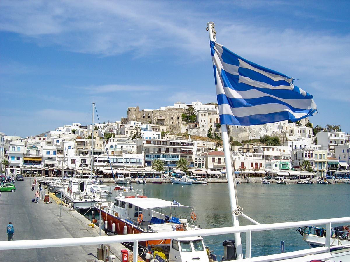 Greek flag boats harbour Naxos and Santorini exploring Greece