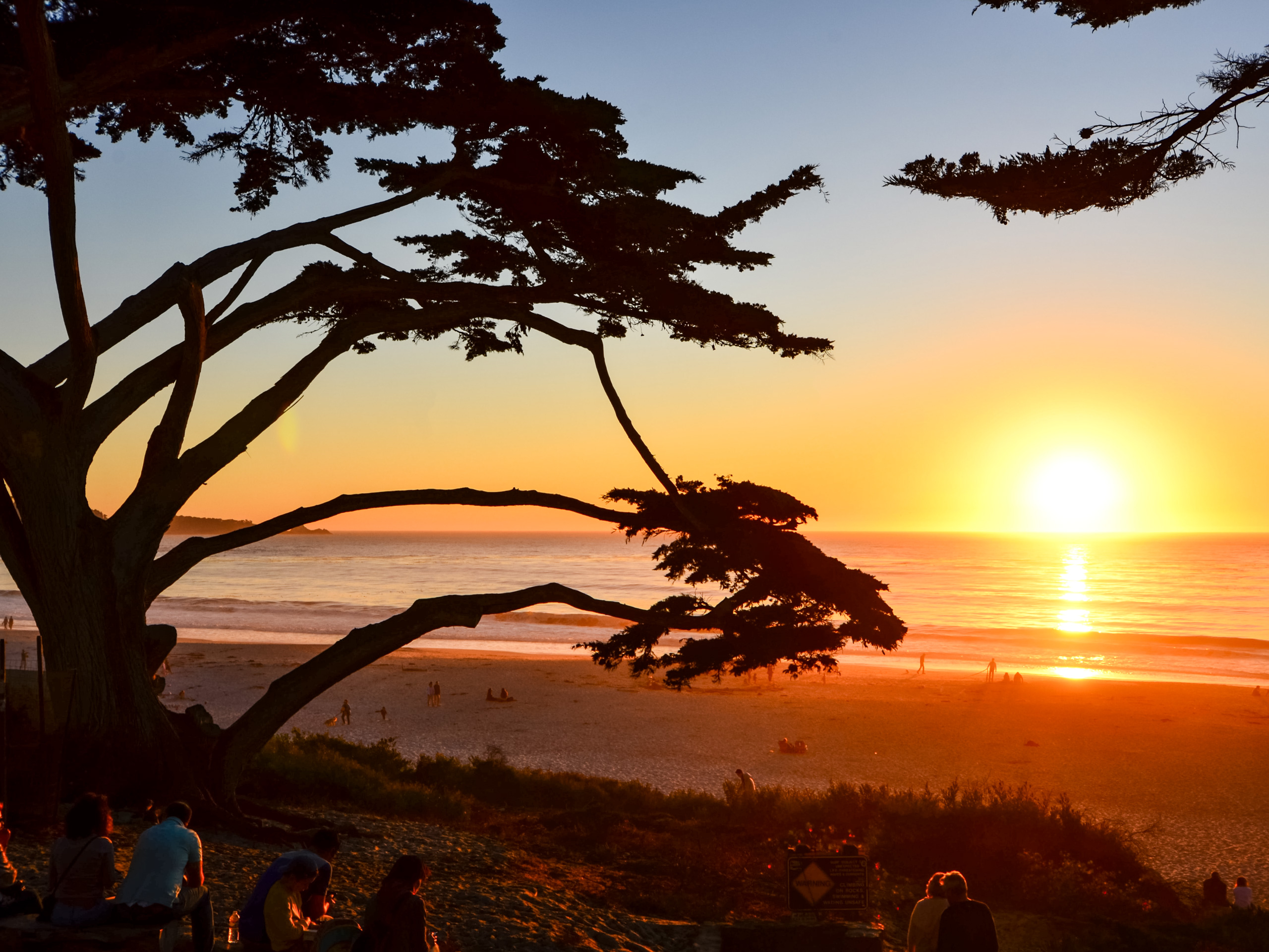 Beachgoers watching the sunset over the Pacific from the beach Carmel Valley CA USA