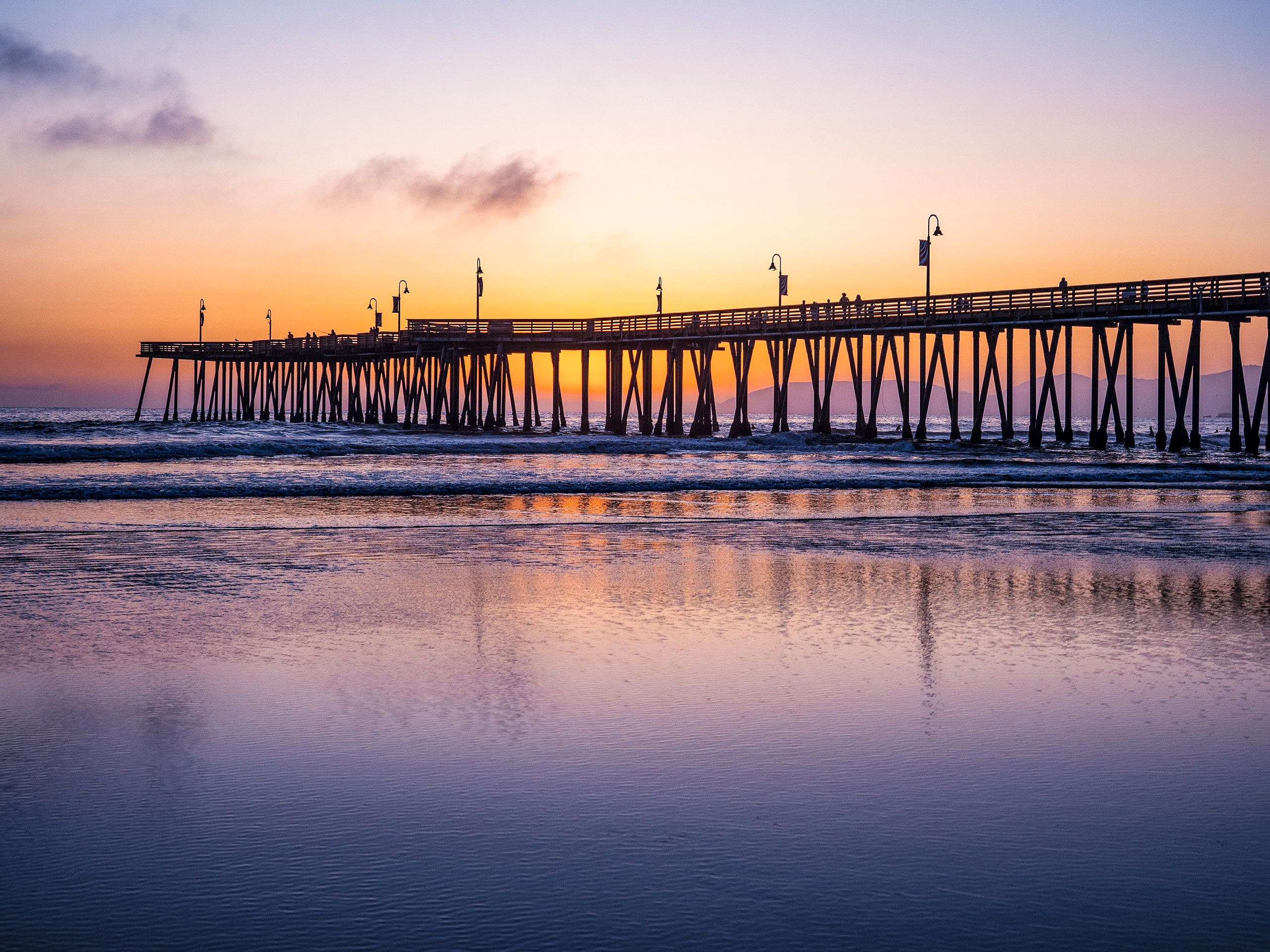 Sunset over the pier and ocean Pismo Beach California road biking adventure