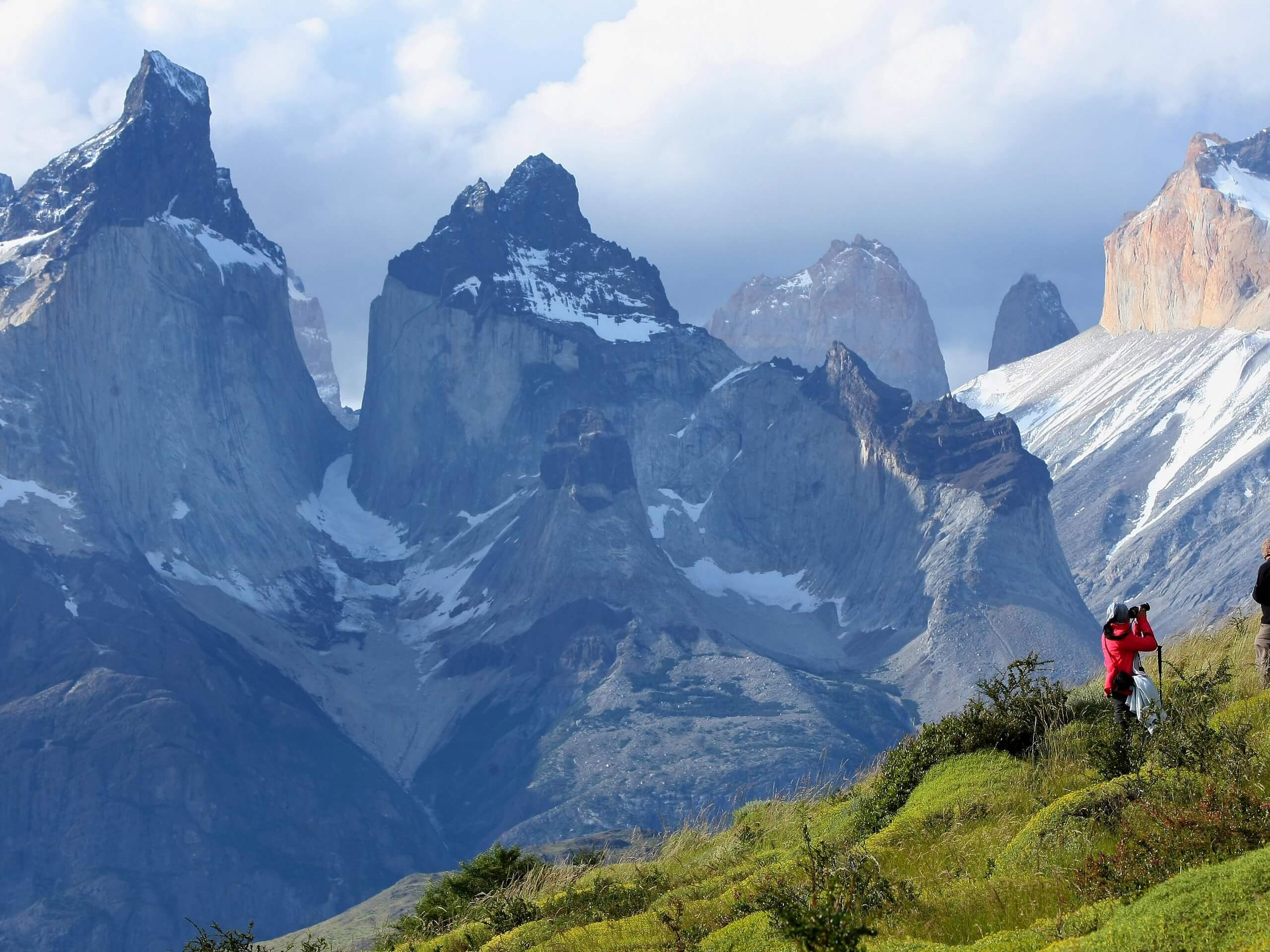 Two hikers taking photos of the peaks of Torres del Paine