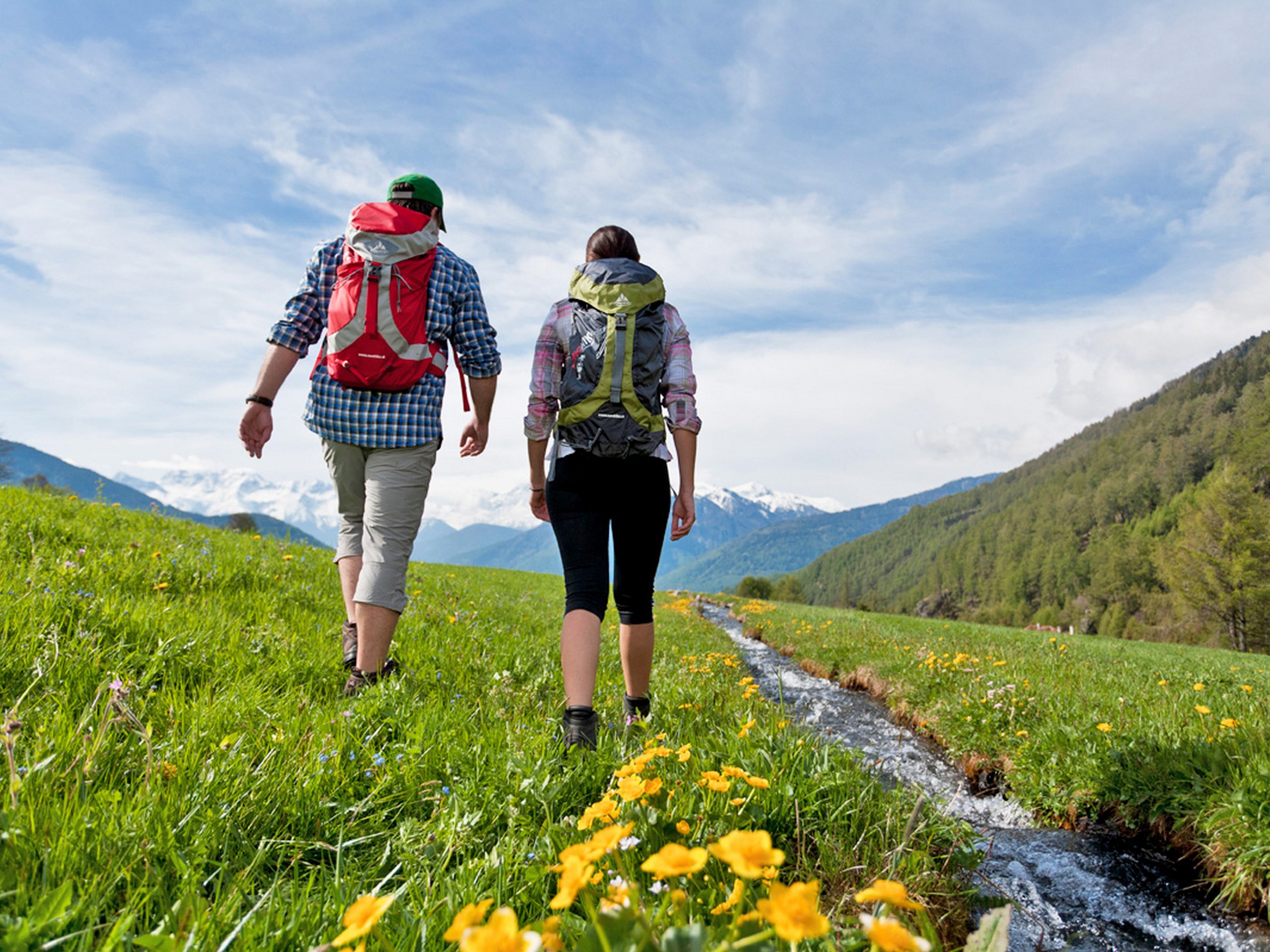 Couple walking in the green meadows of South Tyrol