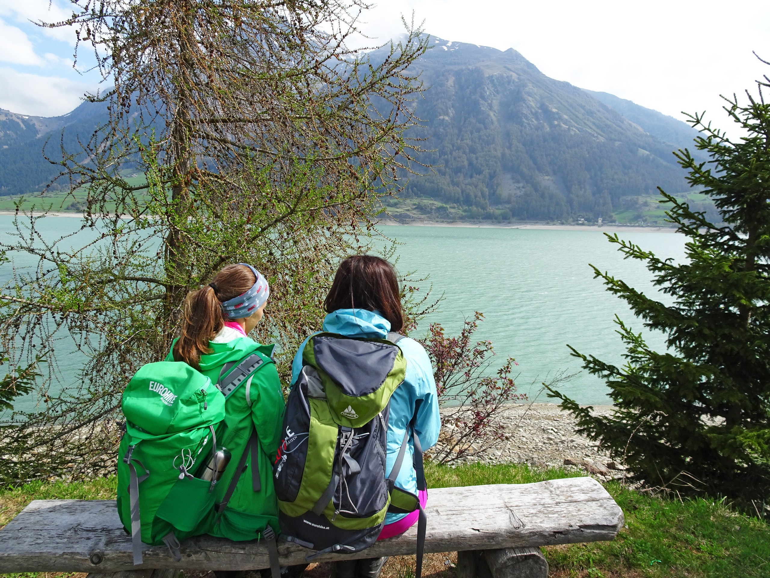 Two walkers resting near the beautiful lake in South Tyrol